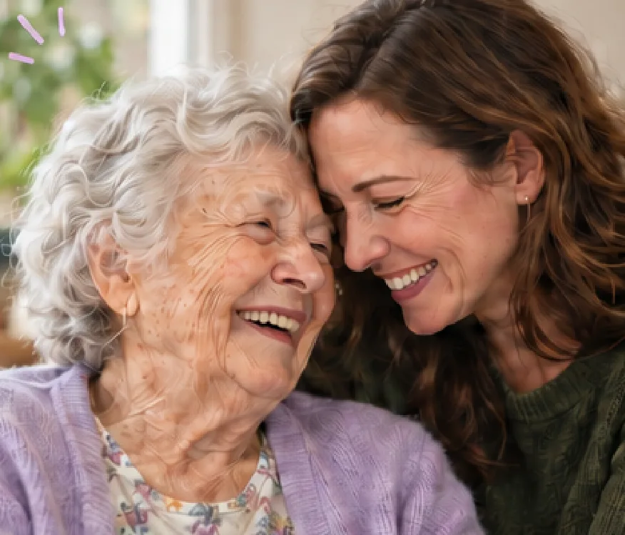 An older woman and her adult daughter laughing together, foreheads touching.